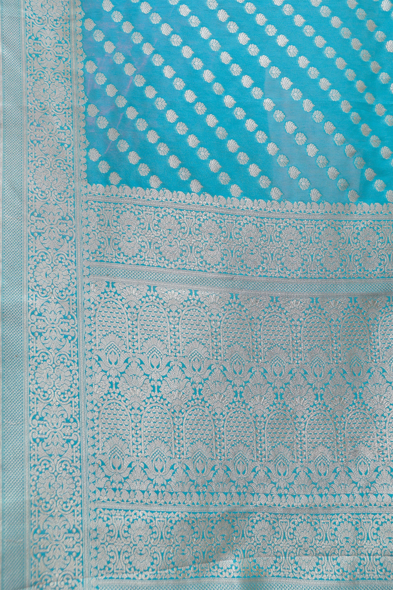 Close-up of intricate zari motifs on light blue handloom Banarasi silk saree – detailed craftsmanship view.