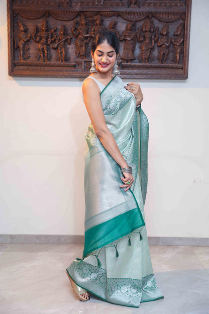Model wearing Handloom Banarasi saree in dual green tones with subtle zari work and heavy border – traditional ethnic wear.